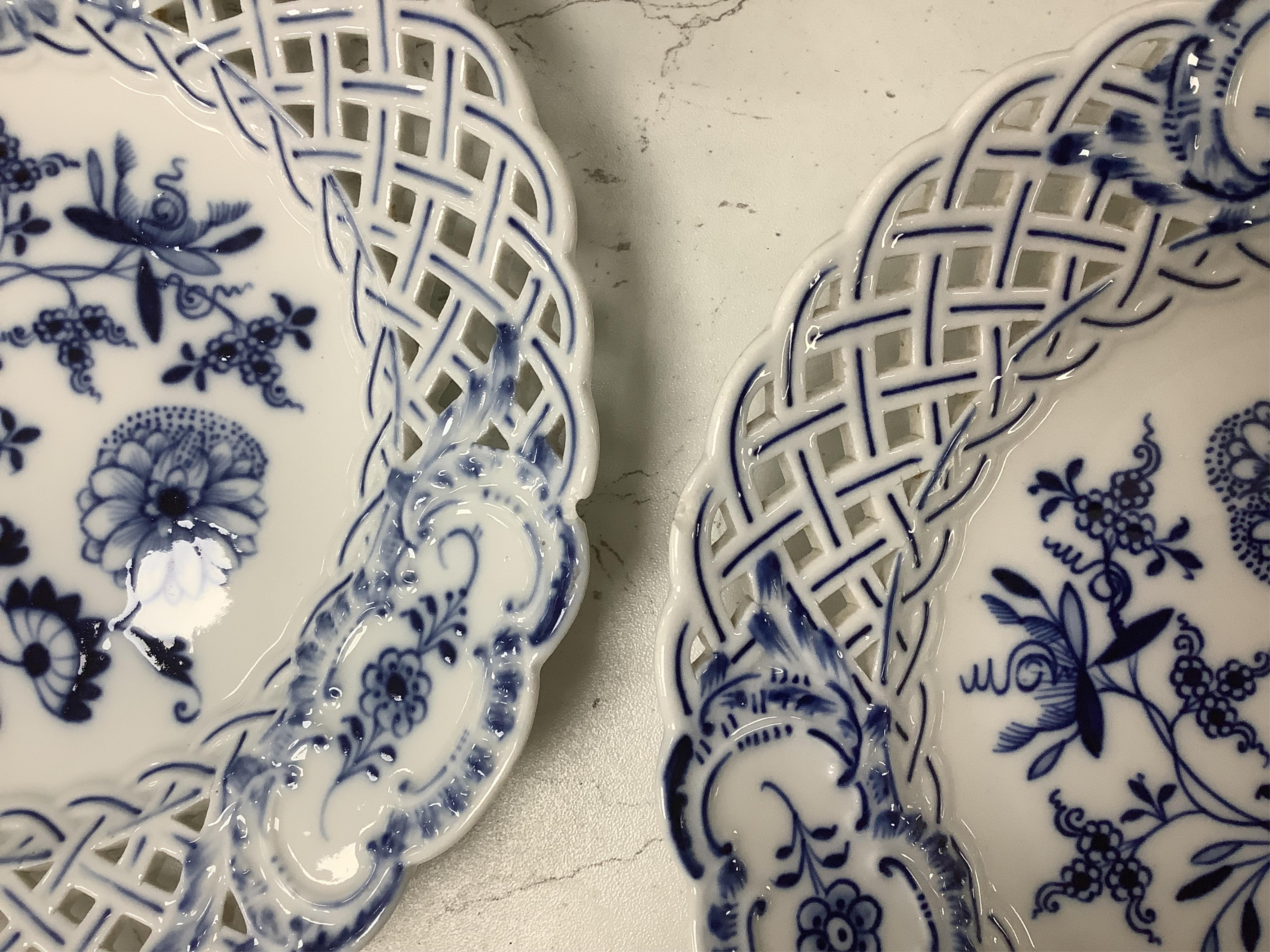 A late 19th Meissen blue and white onion pattern dessert service, consisting of a pair of comports and twelve dishes, all with pierced borders, (14). Condition - poor to good, two plates with pieces of border missing, on